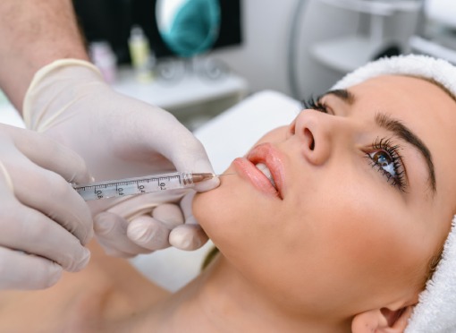 dermal filler patient model receiving an injection to her lip