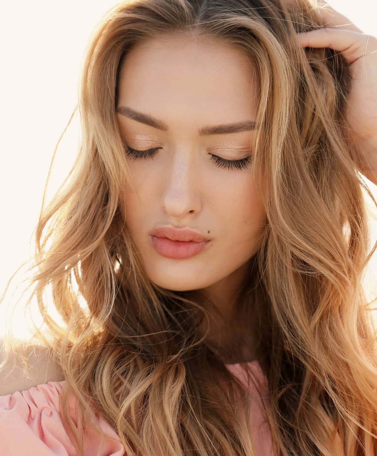 blonde hormone replacement patient model pursing her lips and touching her hair