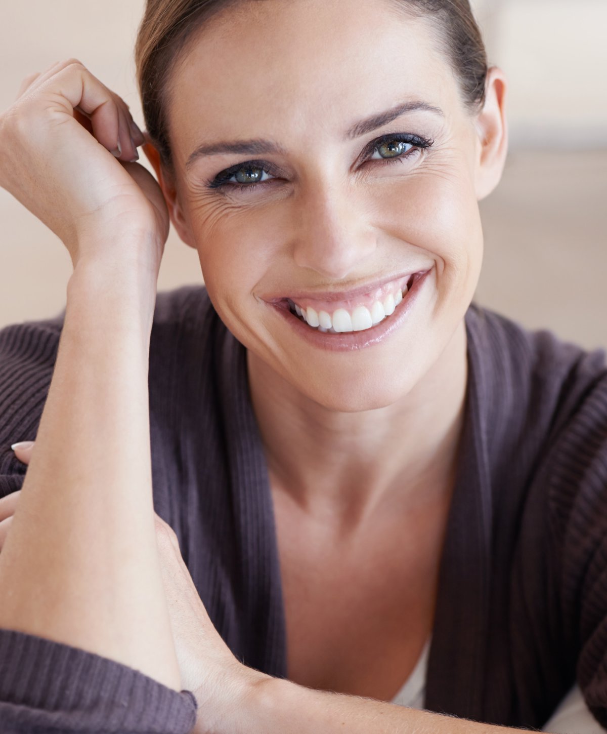 brunette MicroLaserPeel patient model in a lavender cardigan smiling broadly