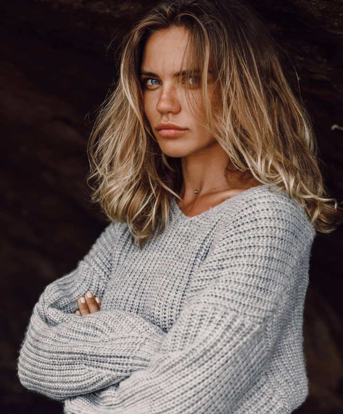 blonde otoplasty patient model in a knit sweater